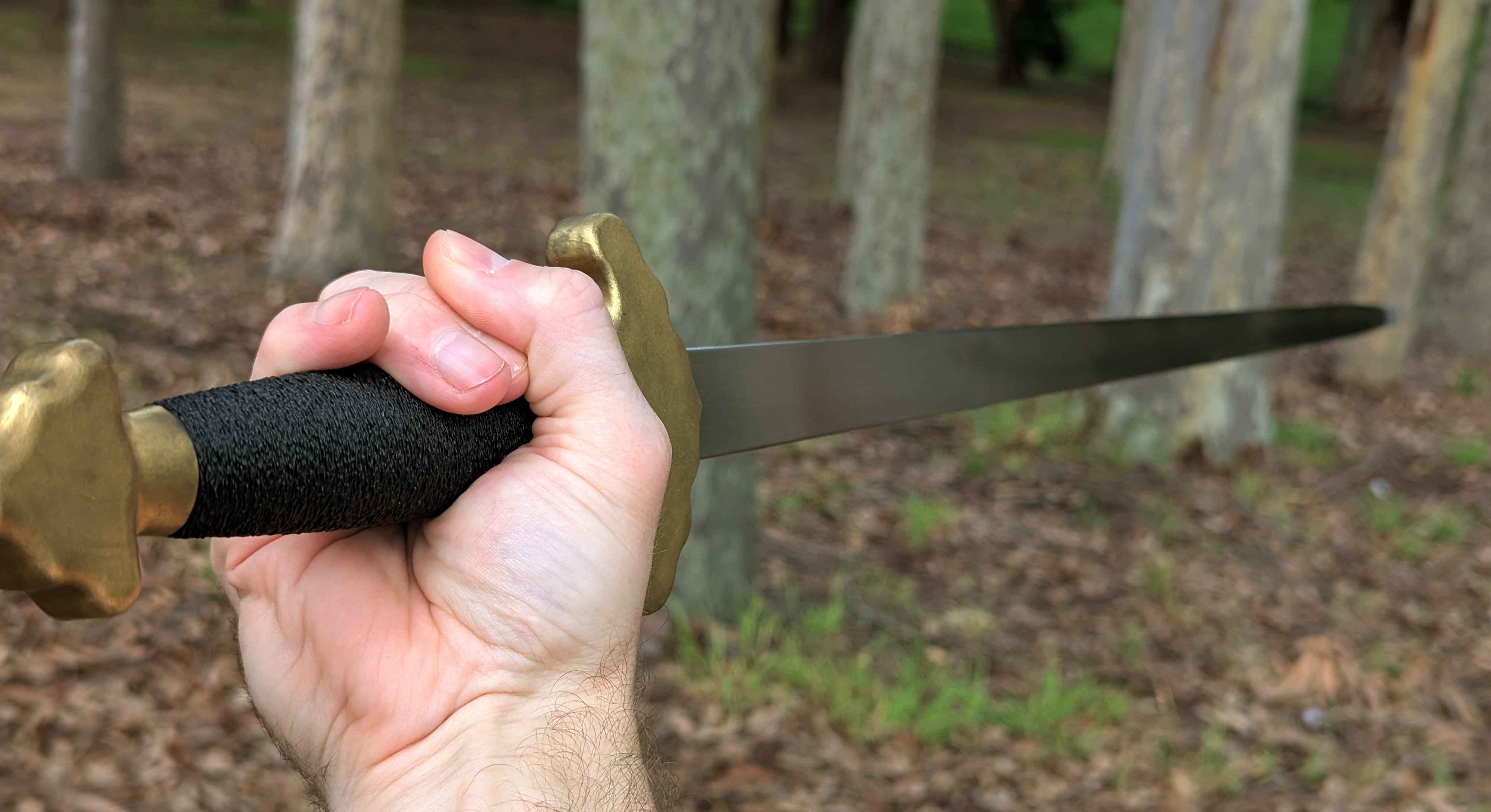 Castille Armory Jian held in a reverse grip